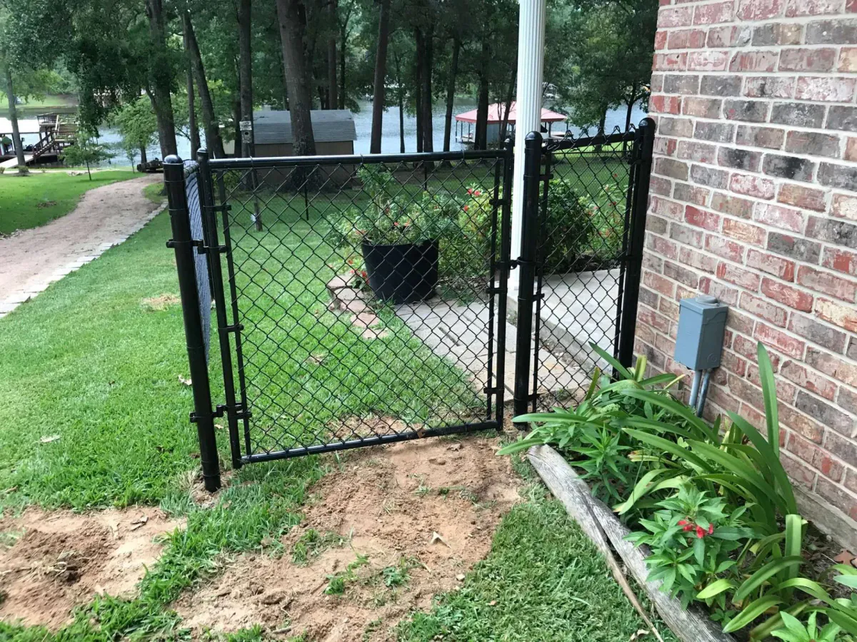 Chain link fence with gate installed in a yard